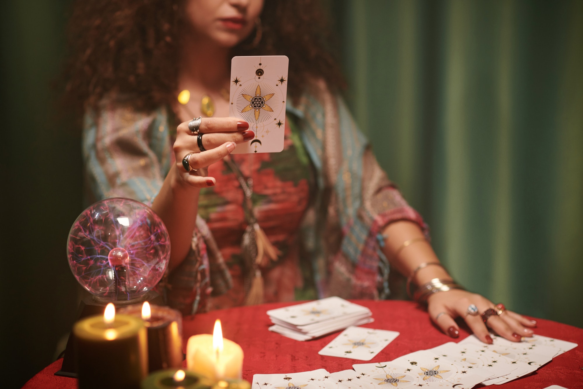 Cropped image of witch taking major arcana, tarot card from table