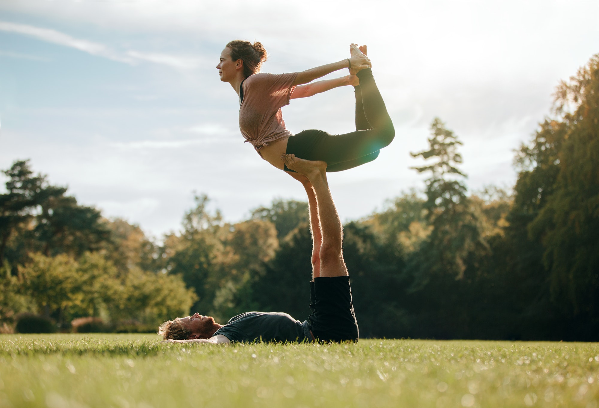 Fit young couple doing acro yoga