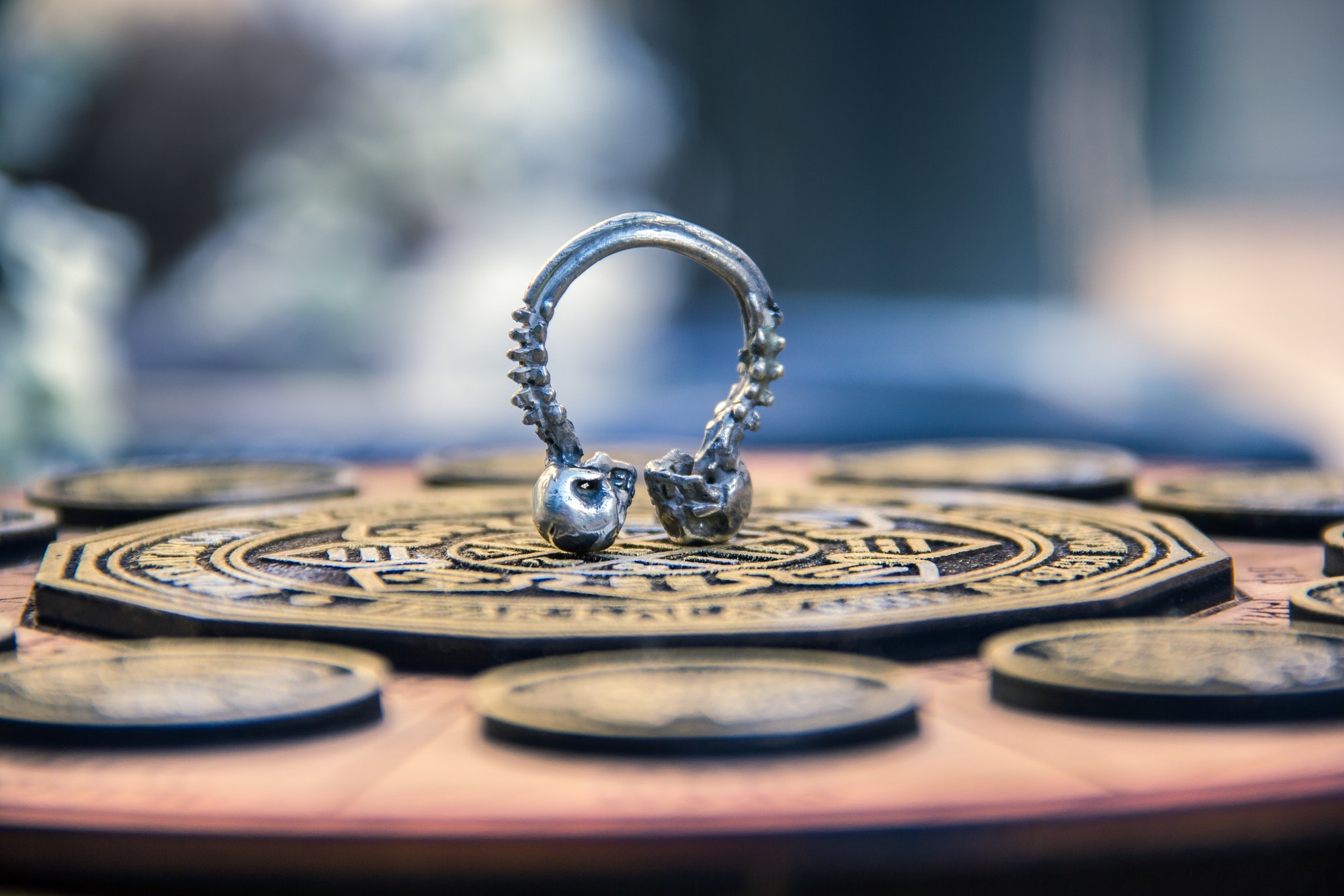 Shallow focus closeup shot of a skull septum piecing on an astrological calendar